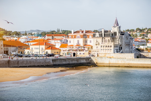 Vista de la puesta de sol en la playa con el palacio Palmela en la localidad portuguesa de Cascais