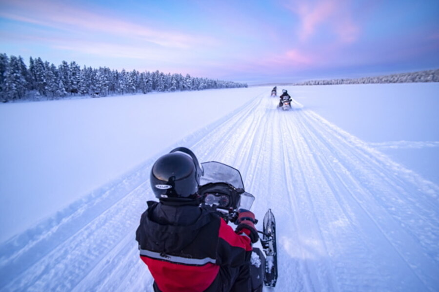 Motos de nieve en el lago helado al atardecer en Torassieppi, Laponia, Finlandia