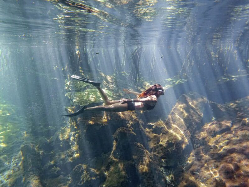 Mujer buceando en un cenote en México