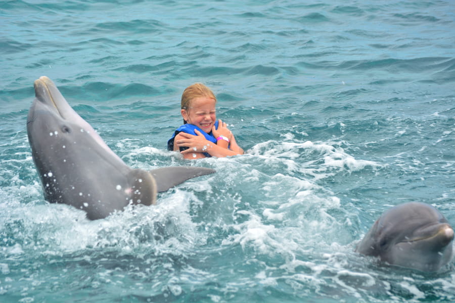 Chica nadando con delfines