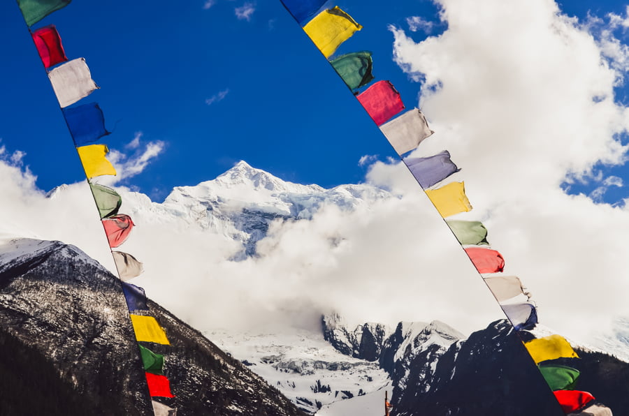 Pico de la montaña del Himalaya y banderas de colores de Nepal
