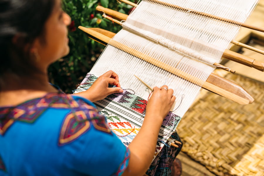 Mujer Maya cosiendo telas tradicionales