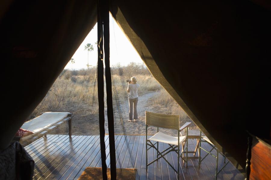 Mujer tomando una fotografía al atardecer, en el desierto de Kalahari